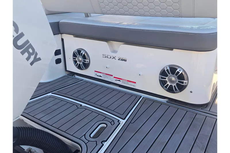 Slide: The Image of 2024 Sea Ray SDX 250 Outboard boat interior with speakers and cushioned seating. - 21