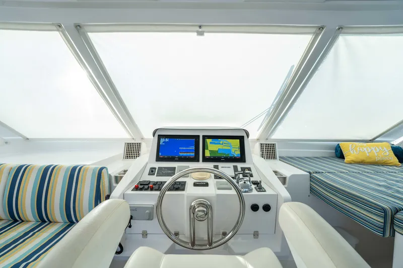 Slide: The Image of Helm of 2016 Horizon PC52 yacht with striped seating and navigation screens. - 43