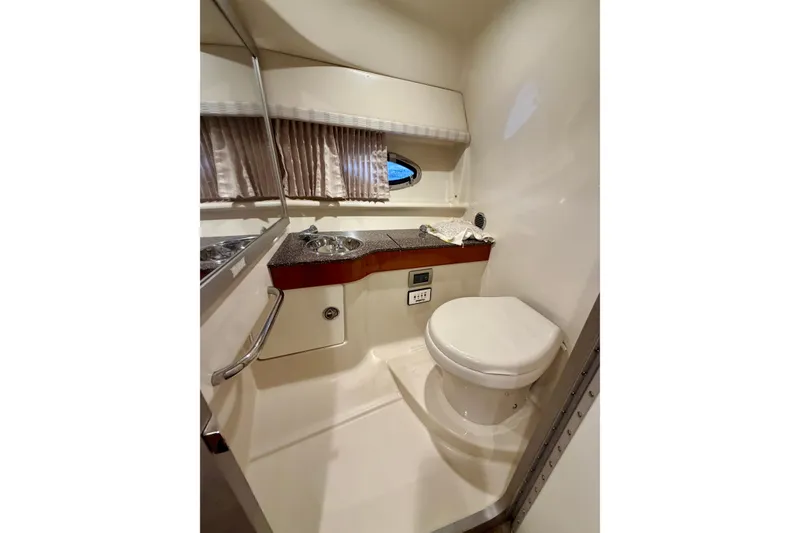 Slide: The Image of 2007 Formula 310 Sun Sport boat bathroom with sink, toilet, and porthole window. - 38