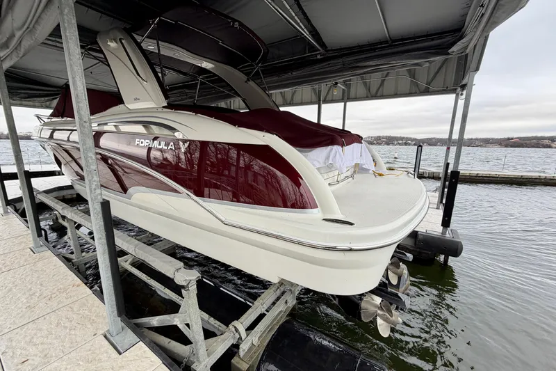 Slide: The Image of 2007 Formula 310 Sun Sport boat docked under a canopy by the water. - 8