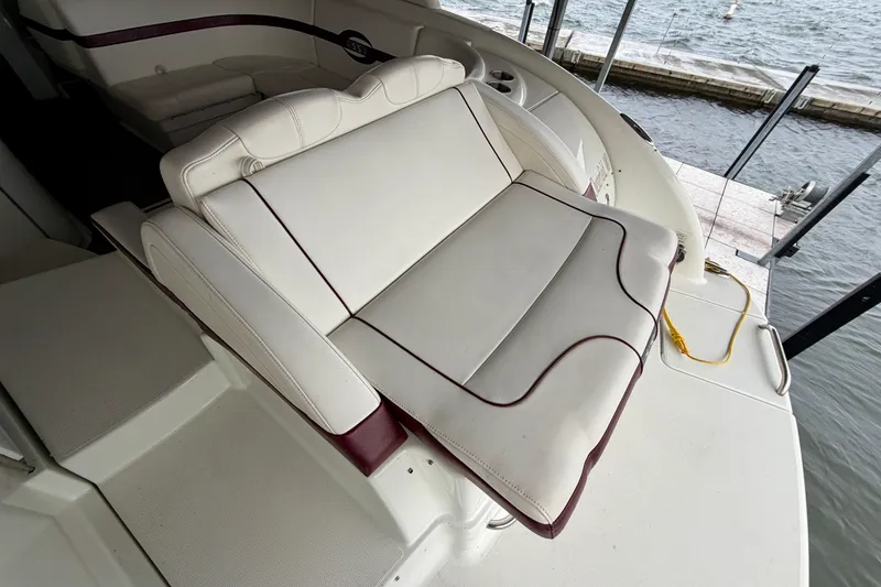 Slide: The Image of 2007 Formula 310 Sun Sport boat interior with white and maroon seating by the water. - 9