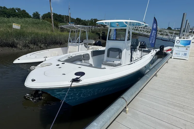 The Image of 2025 NauticStar 292 Legacy boat docked at marina under clear blue sky. - 1