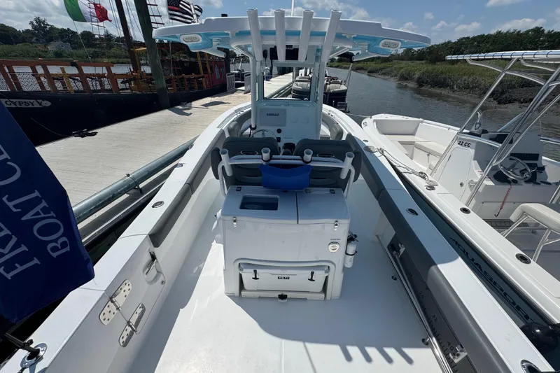 Slide: The Image of 2025 NauticStar 292 Legacy boat docked, showcasing spacious deck and seating area. - 4