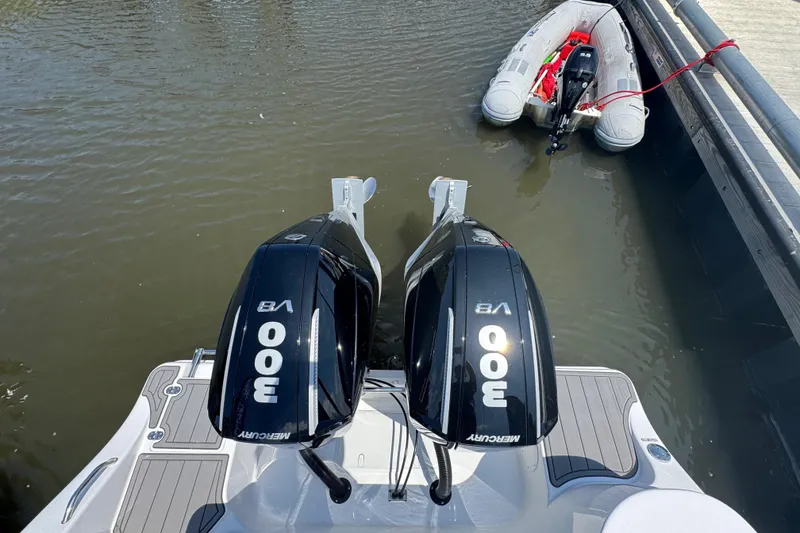 Slide: The Image of 2025 NauticStar 292 Legacy with twin Mercury 300 V8 engines docked beside an inflatable boat. - 5