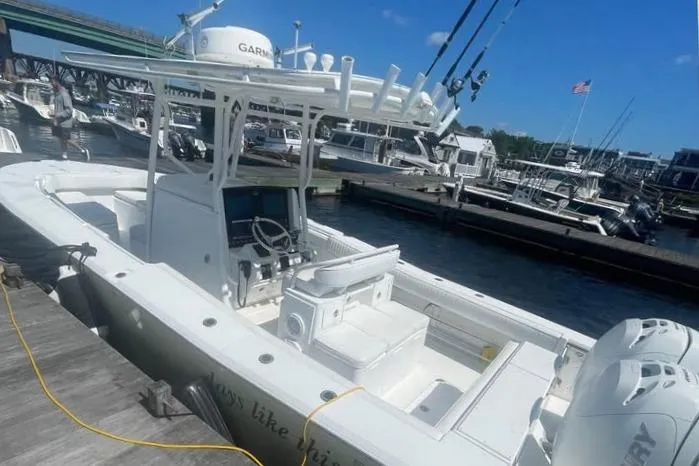 Slide: The Image of 2005 Southport 26 Center Console boat docked at a marina under a clear blue sky. - 5