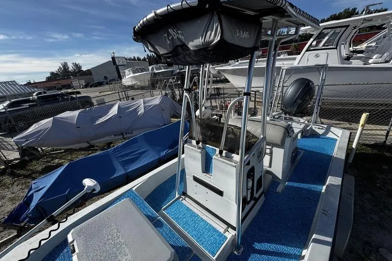 Slide: The Image of 2001 Gulf Coast 200 boat with blue deck, parked in a marina. - 12