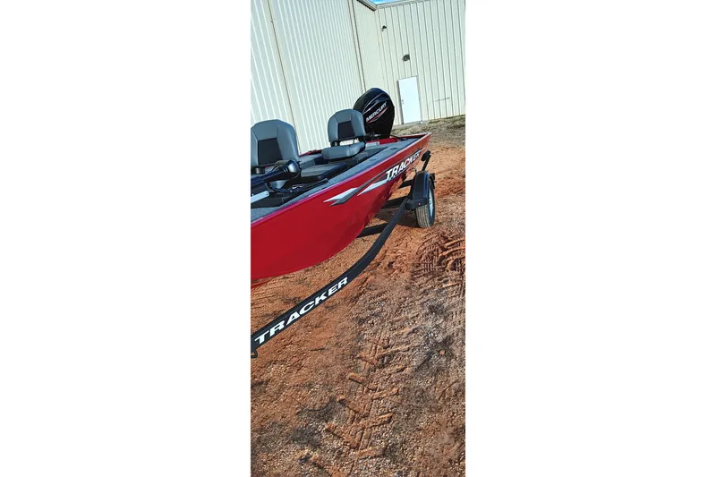 Slide: The Image of 2026 Tracker Panfish 17 boat on trailer, red exterior, parked on dirt. - 20