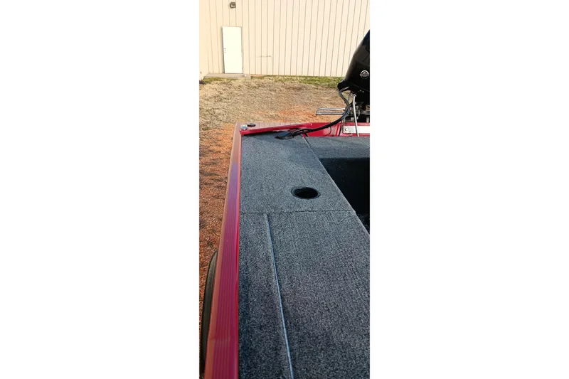 Slide: The Image of 2026 Tracker Panfish 17 boat deck with red trim, outdoor setting. - 5