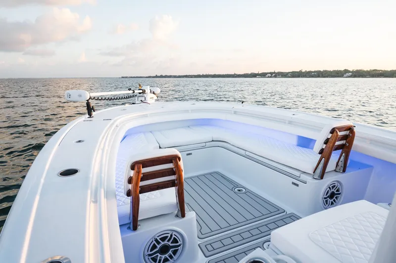 Slide: The Image of 2026 Barker Boatworks 26 Open on calm water at sunset, featuring sleek seating and modern design. - 13