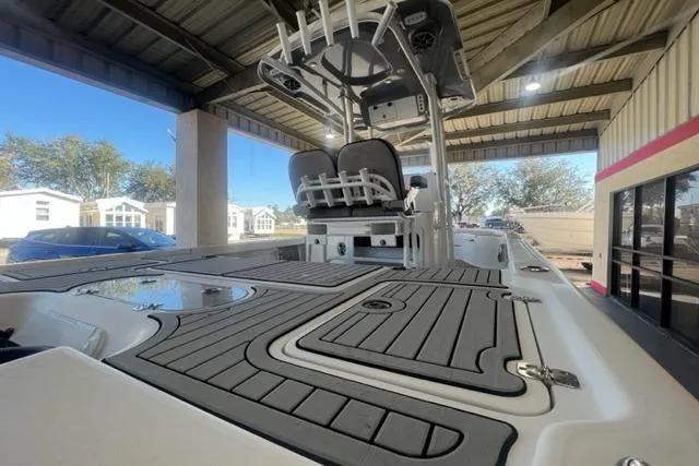 Slide: The Image of 2021 Seapro 248 boat with sleek deck design under a covered area. - 24