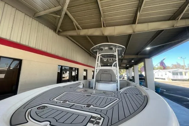 Slide: The Image of 2021 Seapro 248 boat under a covered area, showcasing deck and console. - 30