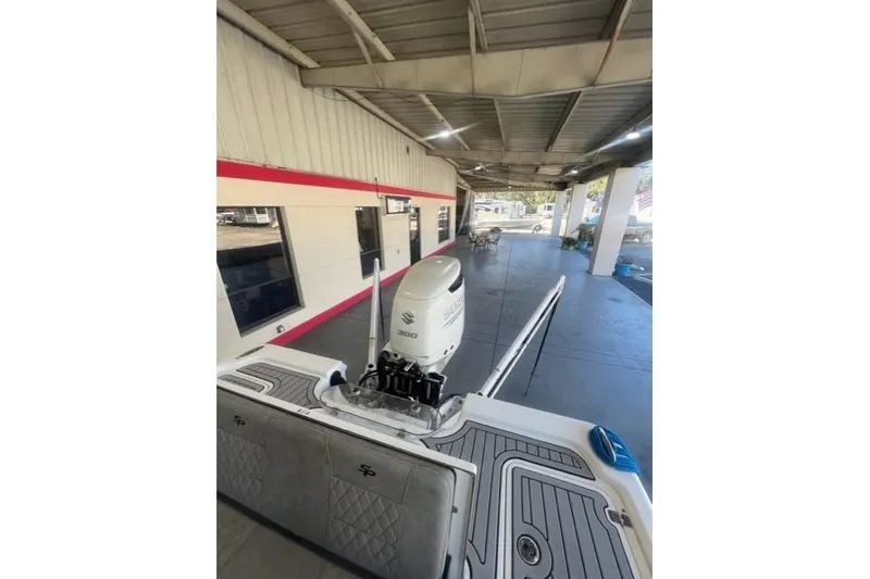 Slide: The Image of 2021 Seapro 248 boat with Suzuki engine in a covered area. - 32
