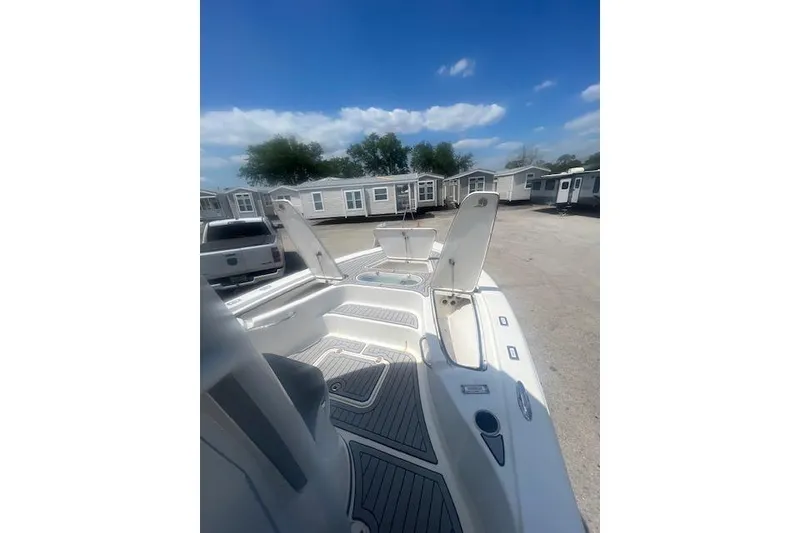 Slide: The Image of 2021 Seapro 248 boat interior with open compartments, parked near mobile homes. - 35