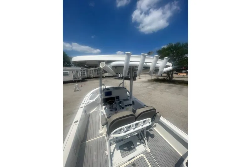 Slide: The Image of 2021 Seapro 248 boat interior with helm, rod holders, and seating under a blue sky. - 38