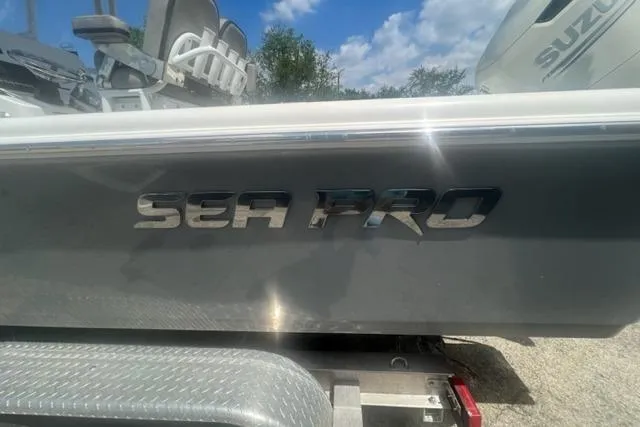 Slide: The Image of 2021 Seapro 248 boat with metallic logo, parked on a trailer under a blue sky. - 39