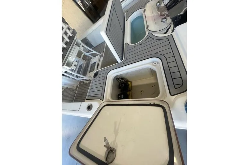 Slide: The Image of 2021 Seapro 248 boat deck with open storage compartments and seating area. - 7