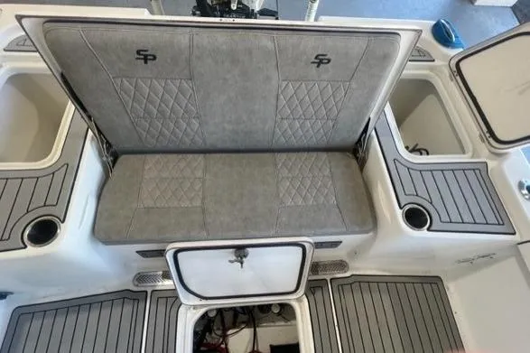 Slide: The Image of 2021 Seapro 248 boat interior with gray cushioned seating and storage compartments. - 8