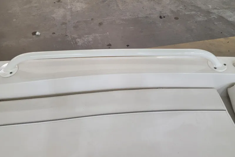 Slide: The Image of 2025 Ranger 2360 Bay boat interior with white seating and grab rail. - 23