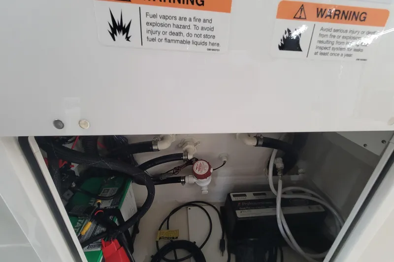 Slide: The Image of 2025 Ranger 2360 Bay boat compartment with warning labels and electrical components. - 26