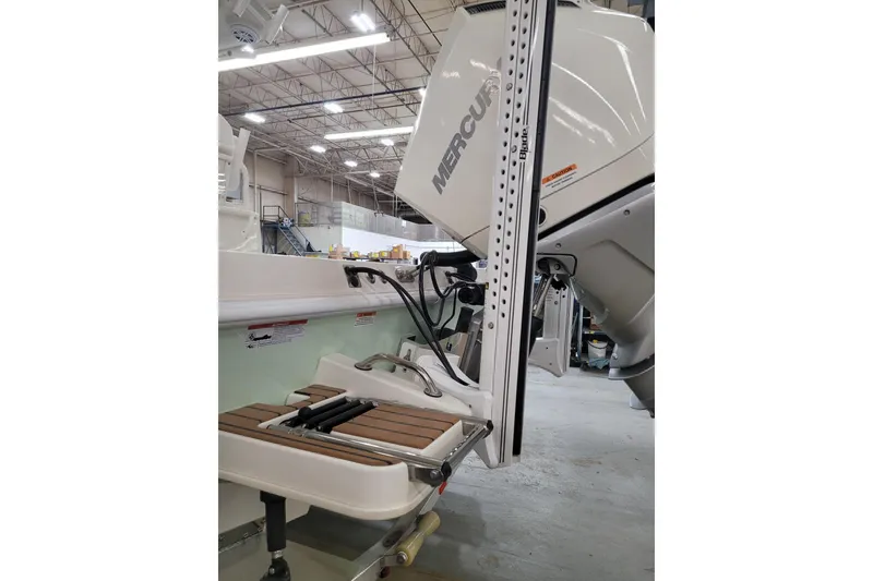 Slide: The Image of 2025 Ranger 2360 Bay boat with Mercury engine in a warehouse setting. - 28