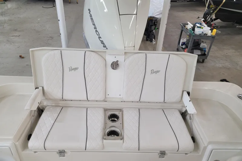 Slide: The Image of 2025 Ranger 2360 Bay boat seating with white cushioned seats and cup holders. - 5
