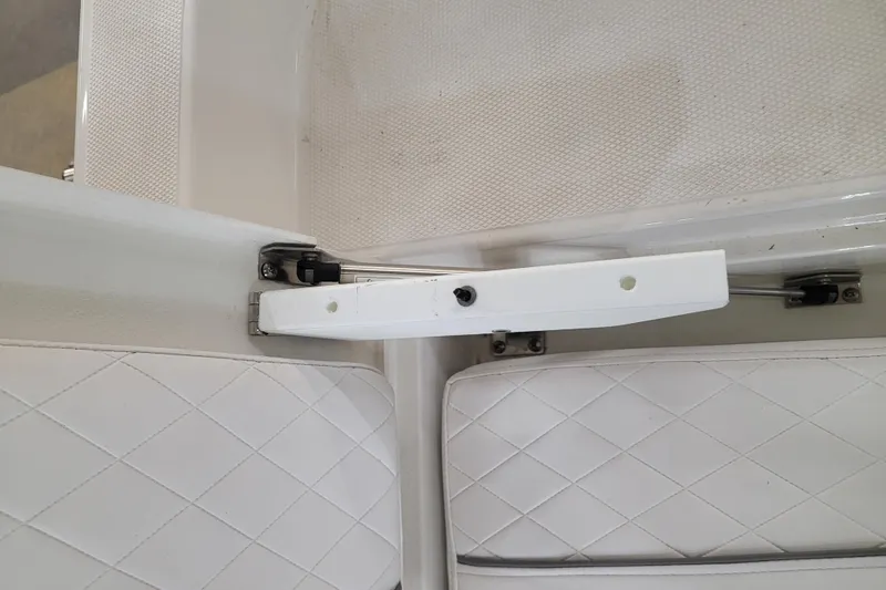 Slide: The Image of 2025 Ranger 2360 Bay boat interior with white cushioned seating and hinge mechanism. - 6