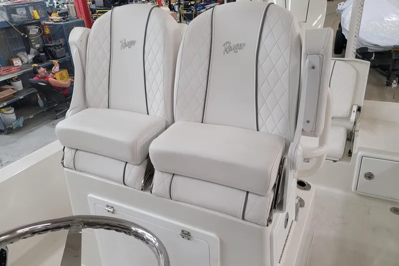 Slide: The Image of 2025 Ranger 2360 Bay boat with luxurious white leather seats in a workshop setting. - 8
