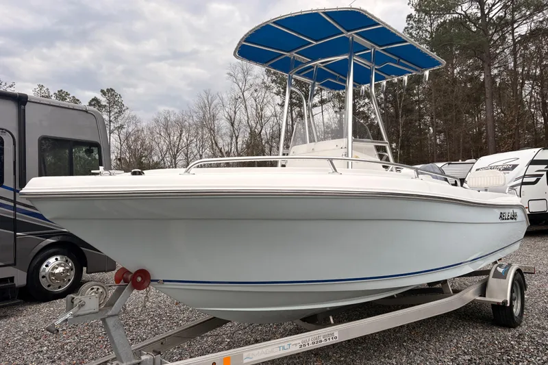 The Image of 2018 Release Boatworks 196 RK on trailer, featuring blue T-top, parked outdoors. - 1