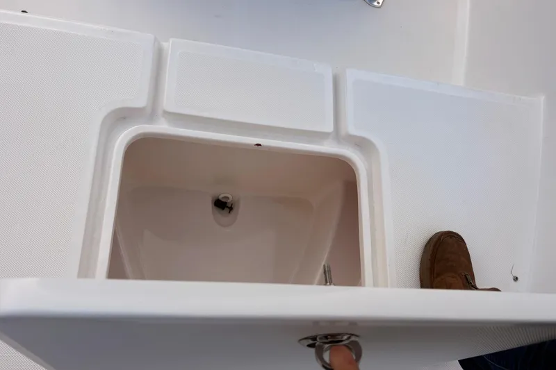 Slide: The Image of Open storage compartment on 2018 Release Boatworks 196 RK deck, with visible latch and shoe. - 8