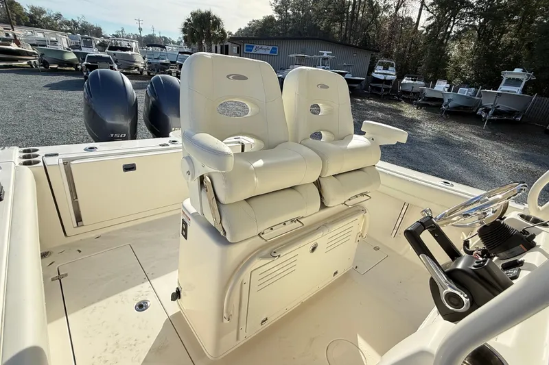 Slide: The Image of 2017 Cobia boat interior with dual seats and steering wheel, parked outdoors. - 10