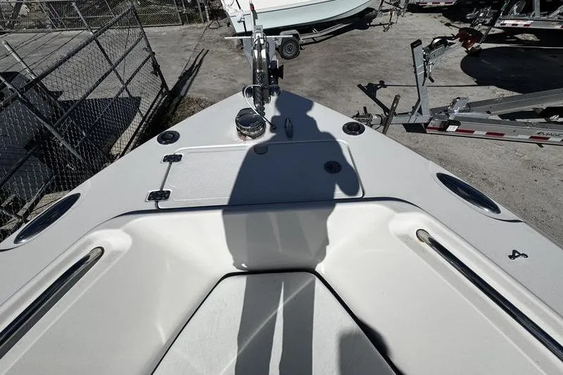 Slide: The Image of 2010 Sailfish 2860 CC boat deck with shadow, parked near trailers. - 10
