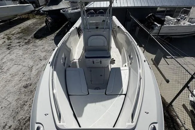 Slide: The Image of 2010 Sailfish 2860 CC boat, spacious deck, white interior, docked outdoors. - 11