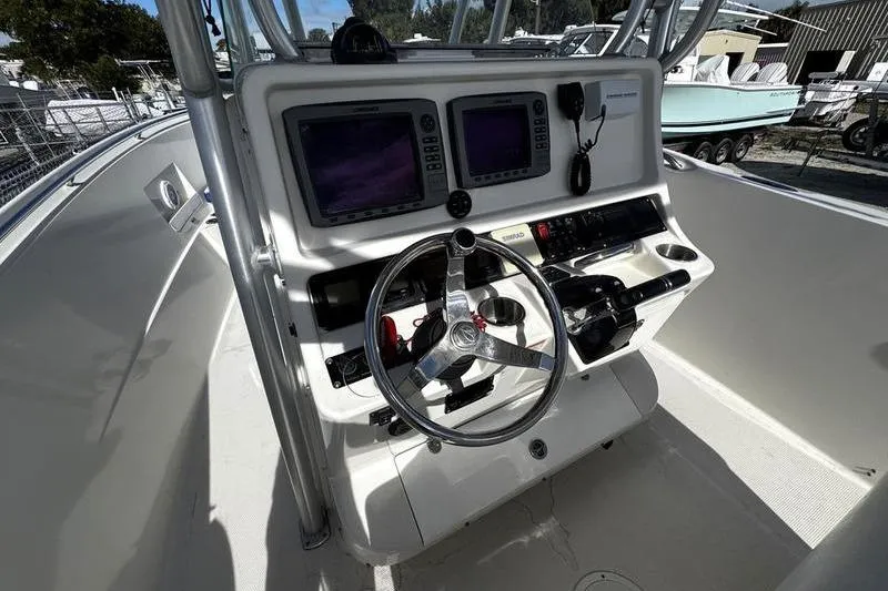 Slide: The Image of 2010 Sailfish 2860 CC boat console with dual screens and steering wheel. - 19