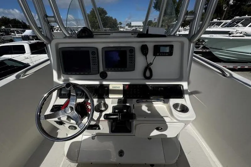 Slide: The Image of 2010 Sailfish 2860 CC boat console with steering wheel, navigation screens, and controls. - 21