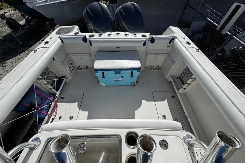 Slide: The Image of 2010 Sailfish 2860 CC boat deck with cooler and fishing rod holders. - 22