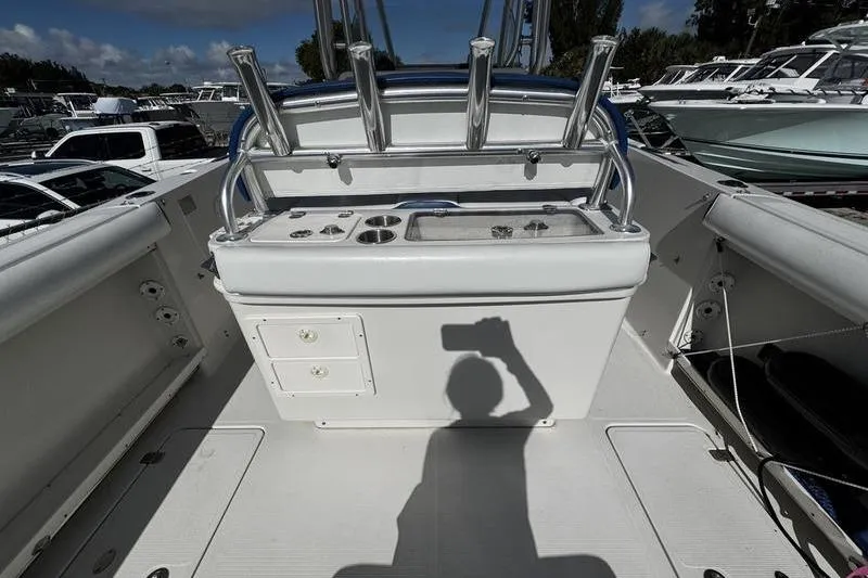 Slide: The Image of 2010 Sailfish 2860 CC boat interior with fishing rod holders and shadow of person taking photo. - 25