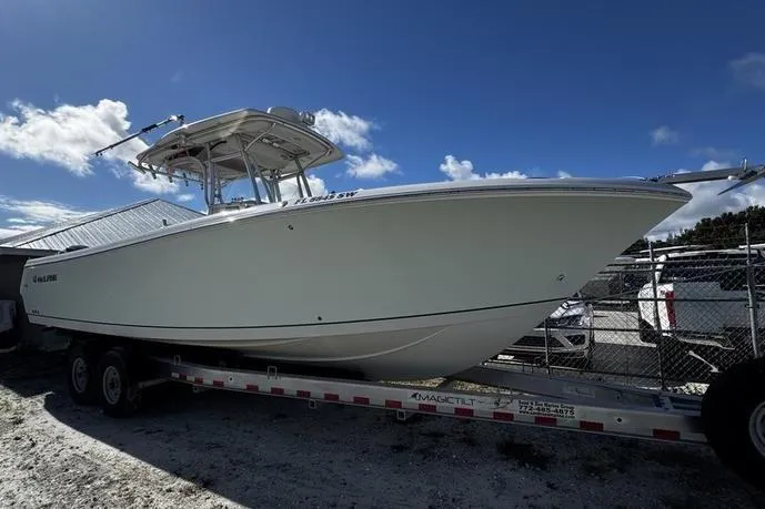 Slide: The Image of 2010 Sailfish 2860 CC boat on trailer under clear blue sky. - 4