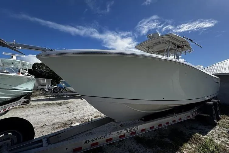 Slide: The Image of 2010 Sailfish 2860 CC boat on trailer under clear blue sky. - 5