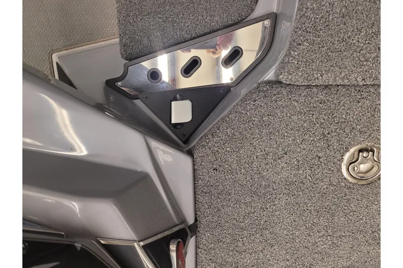 Slide: The Image of 2023 Ranger Z521R boat interior detail with gray carpet and metal fixtures. - 16