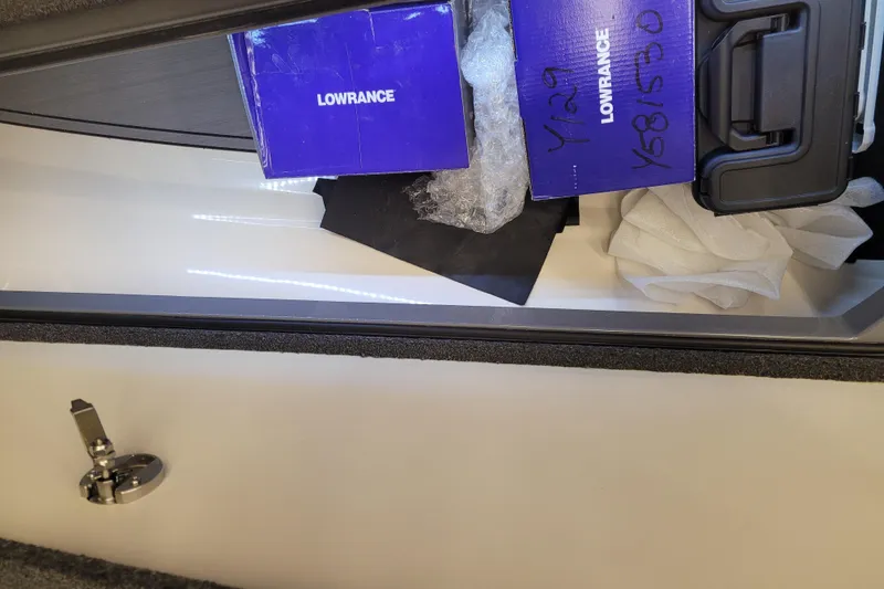 Slide: The Image of 2023 Ranger Z521R storage compartment with Lowrance equipment and packaging materials. - 18