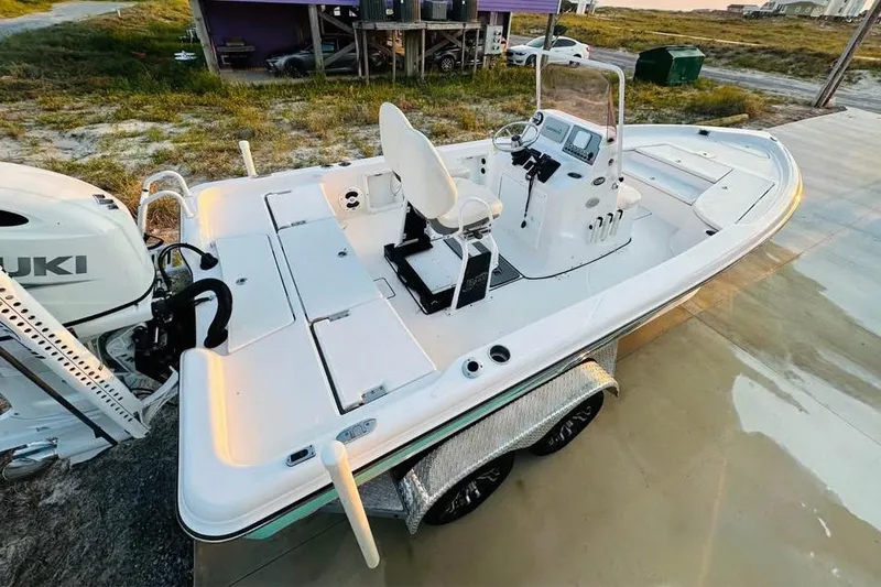 Slide: The Image of 2022 Blue Wave 2200 Classic boat on trailer, featuring a Suzuki outboard motor. - 12