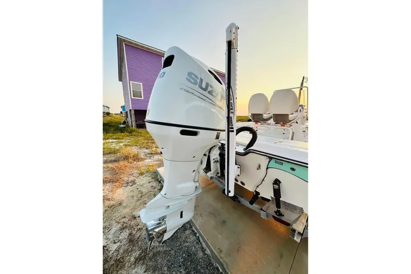 Slide: The Image of 2022 Blue Wave 2200 Classic boat with Suzuki outboard motor, parked near a purple house. - 15