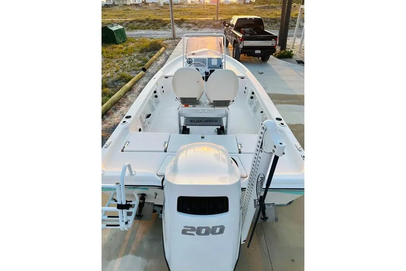 Slide: The Image of 2022 Blue Wave 2200 Classic boat, white exterior, parked on concrete near a truck. - 17