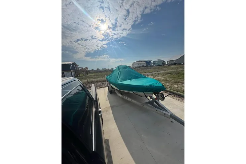 Slide: The Image of 2022 Blue Wave 2200 Classic boat covered on trailer under sunny sky. - 6