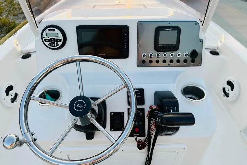Slide: The Image of 2022 Blue Wave 2200 Classic boat console with steering wheel and navigation controls. - 7