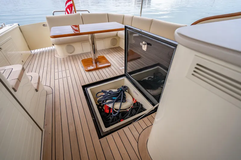 Slide: The Image of 2020 Palm Beach Motor Yachts PB50 deck with storage compartment and seating area. - 11