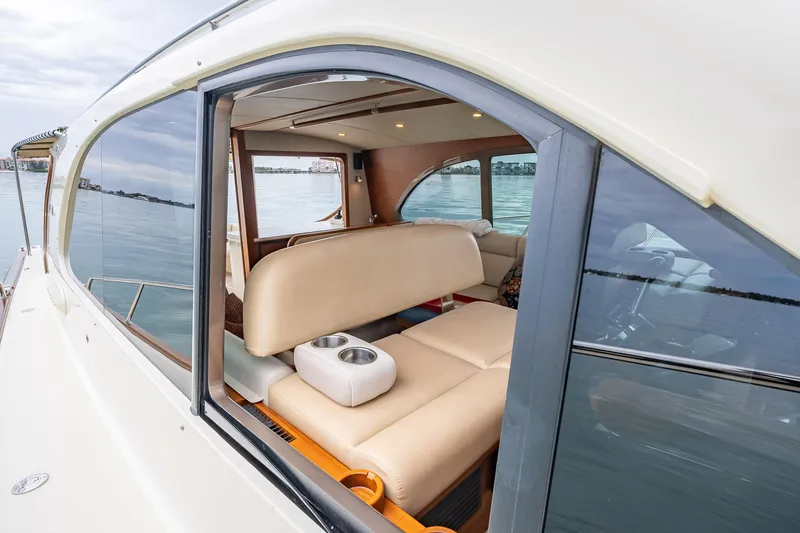 Slide: The Image of 2020 Palm Beach Motor Yachts PB50 interior with beige seating and water view. - 14