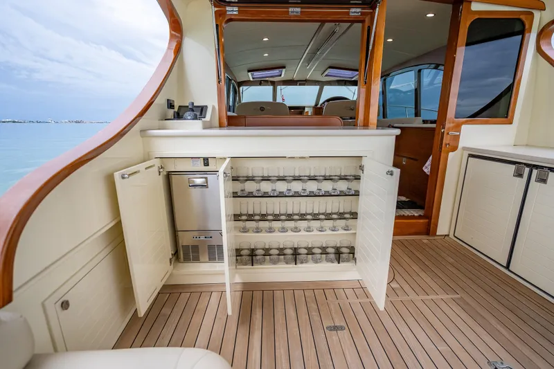 Slide: The Image of 2020 Palm Beach Motor Yachts PB50 interior with open cabinet and glassware storage. - 2