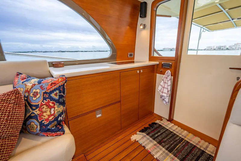 Slide: The Image of Luxurious interior of 2020 Palm Beach Motor Yachts PB50 with wooden cabinetry and colorful cushions. - 22