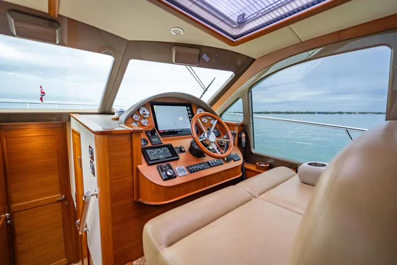 Slide: The Image of 2020 Palm Beach Motor Yachts PB50 helm with luxurious wood finish and modern navigation equipment. - 30